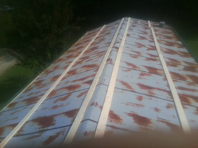 Rusted metal roof panels with new wood purlins before replacement — Storm Damage Roof Repair in Arab by Roofing Brothers