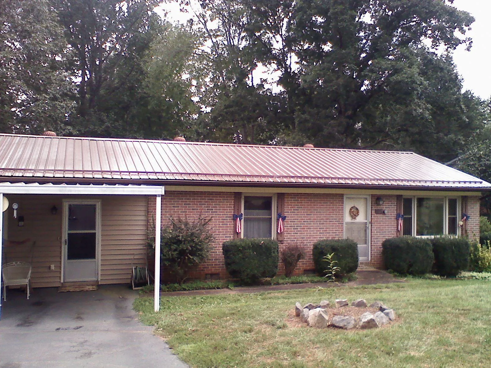 Bronze metal roof and carport on a brick ranch home — Roof Repair work by our crew in Arab