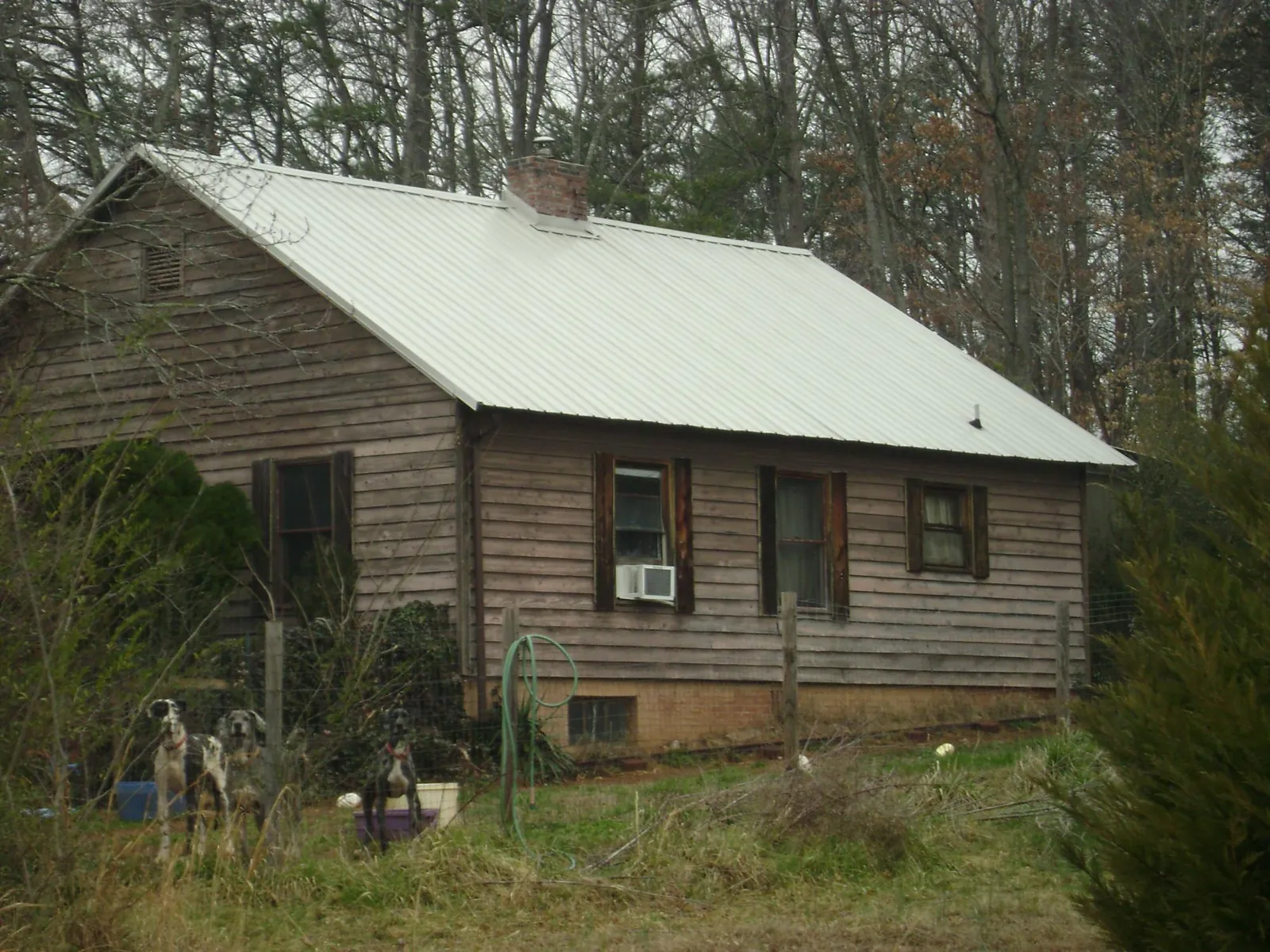 White metal roof on an old wood sided farmhouse, from a Metal Roof Installation job in Arab